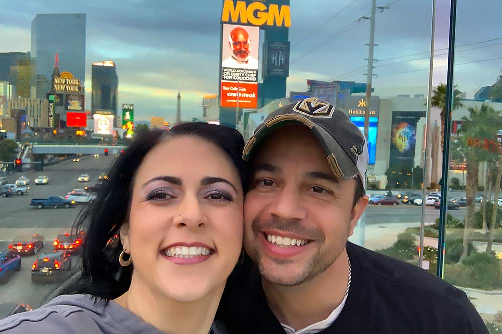 A couple smiling in front of the Las Vegas Strip, featuring bright lights and signs, symbolizing Crown Marketing's expertise in digital marketing services for enhancing brand visibility.| Crown Marketing Digital Marketing Agency Las Vegas