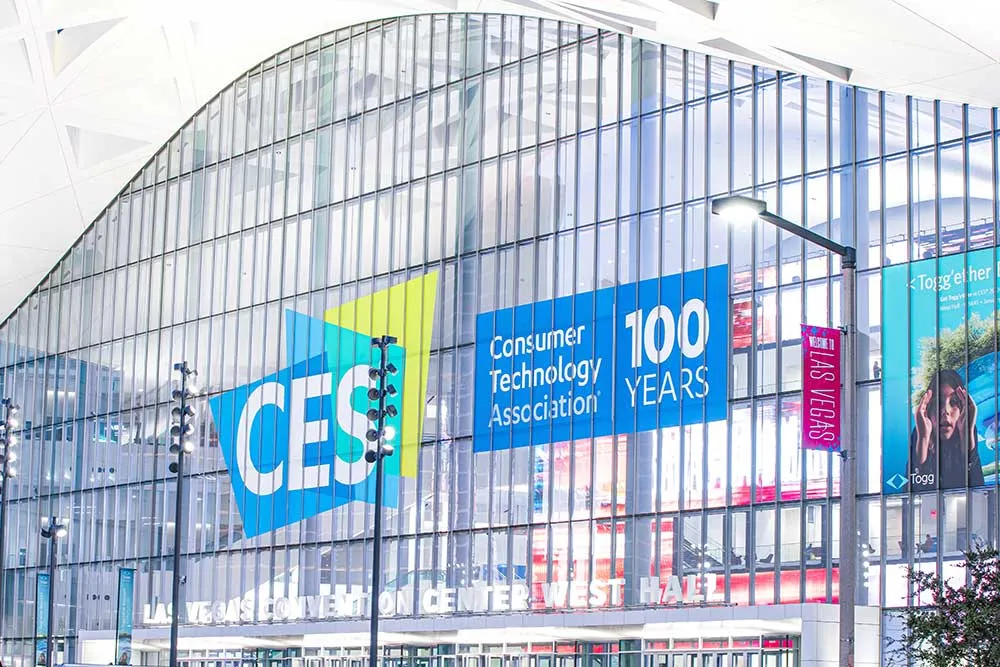 The glass facade of Las Vegas Convention Center displays colorful CES banners, highlighting Las Vegas marketing with Crown Marketing's digital marketing services expertise.| Crown Marketing Digital Marketing Agency Las Vegas