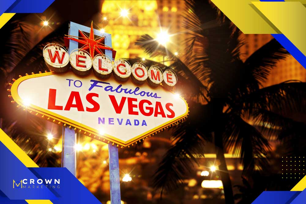Bright "Welcome to Las Vegas" sign at night with glowing lights and palm trees, featuring Crown Marketing's digital marketing services logo in the corner.| Crown Marketing Digital Marketing Agency Las Vegas